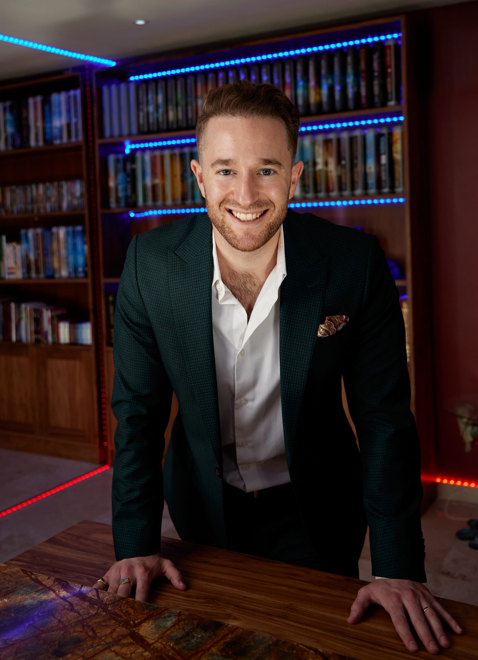 Gal Ezra, serial entrepreneur, international coach and marketing expert, leaning over a desk in his library, looking straight at you.