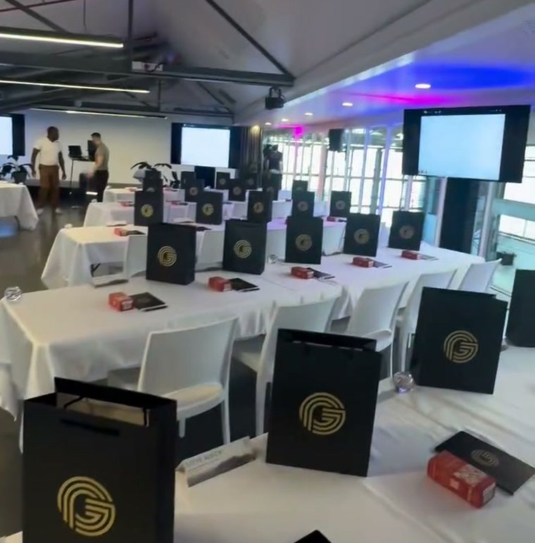Seminar floor set for day one, white tables with Guaranteed Prosperity gift bags and workbooks