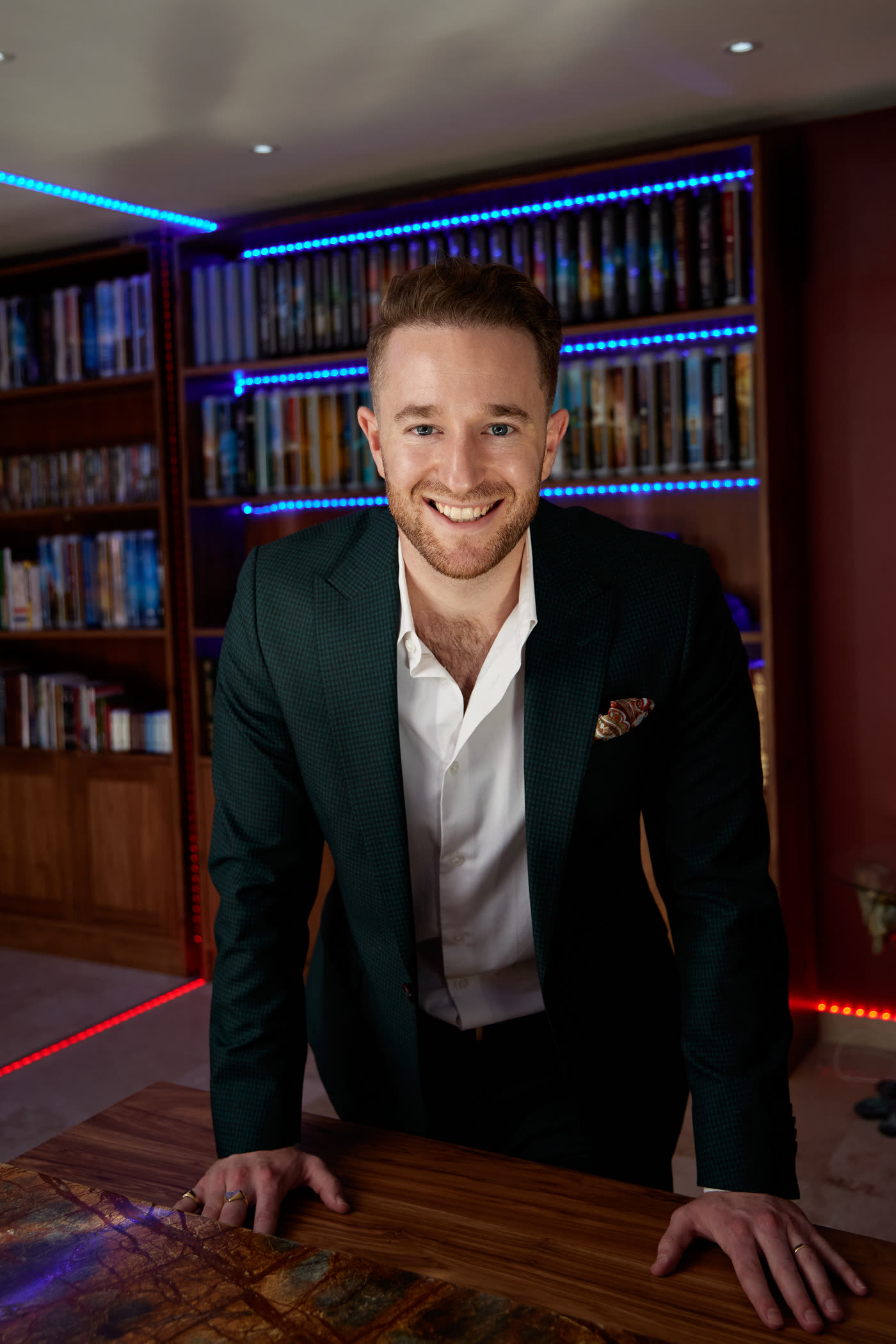 Gal Ezra smiling in his library, CEO of Guaranteed Prosperity